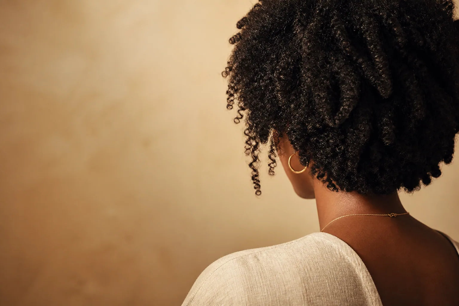 Cheveux afro crépus naturels sur fond beige